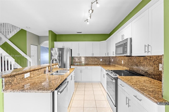 kitchen featuring stainless steel appliances, a kitchen island with sink, sink, light tile patterned floors, and white cabinets