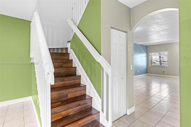 staircase featuring tile patterned flooring