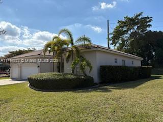 view of property exterior with a garage and a lawn