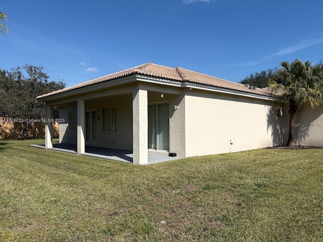 back of house with a yard and a patio area