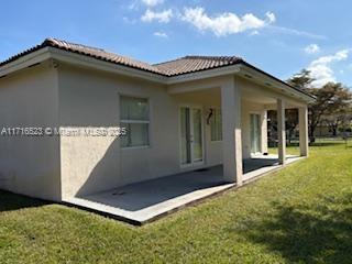 back of house featuring a yard and a patio