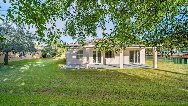 back of house with a patio and a yard