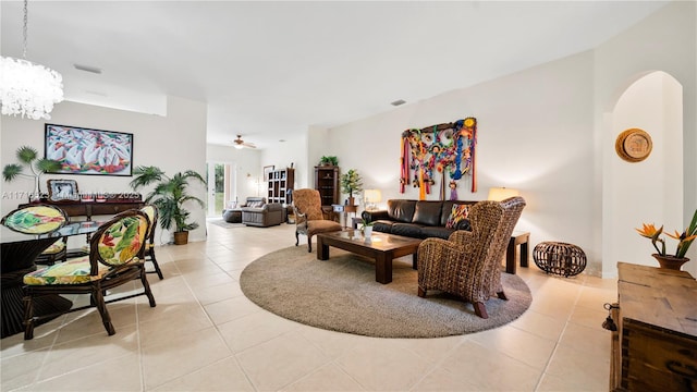 living room with light tile patterned floors and ceiling fan with notable chandelier