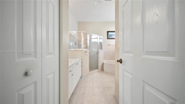 bathroom with vanity, plus walk in shower, and tile patterned flooring