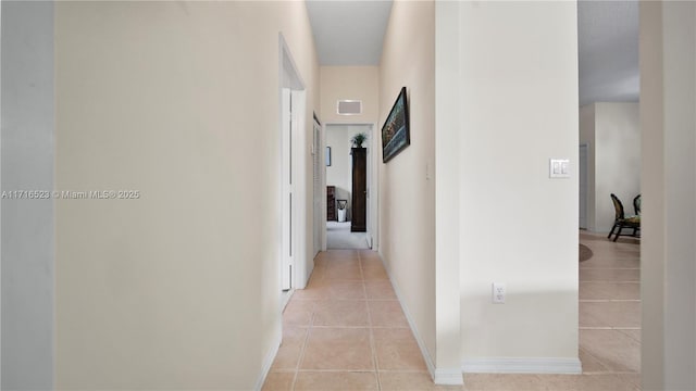 hall with light tile patterned floors