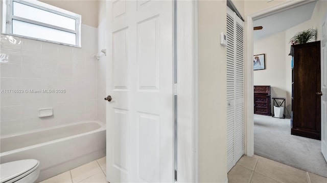 bathroom featuring tile patterned flooring, shower / bathing tub combination, and toilet