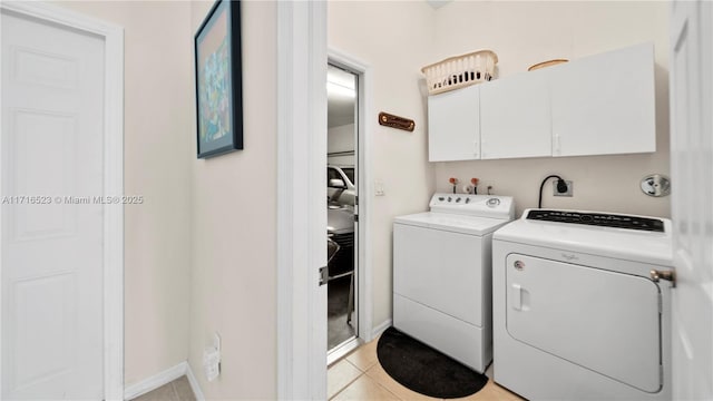 clothes washing area featuring independent washer and dryer, cabinets, and light tile patterned floors