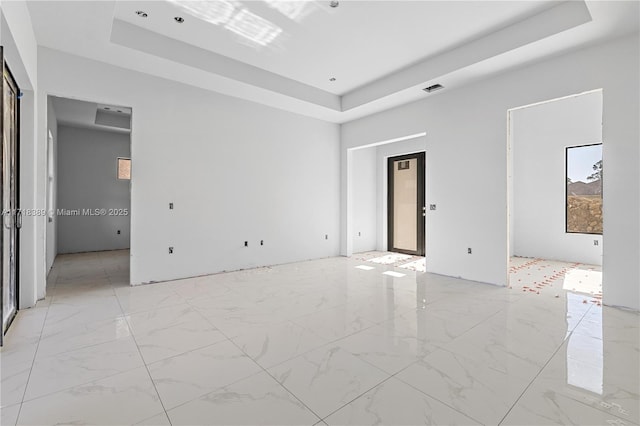 spare room featuring a raised ceiling