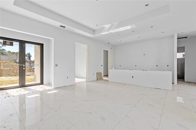 empty room with a raised ceiling and french doors