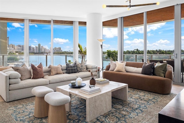 living room with a water view, expansive windows, and a healthy amount of sunlight