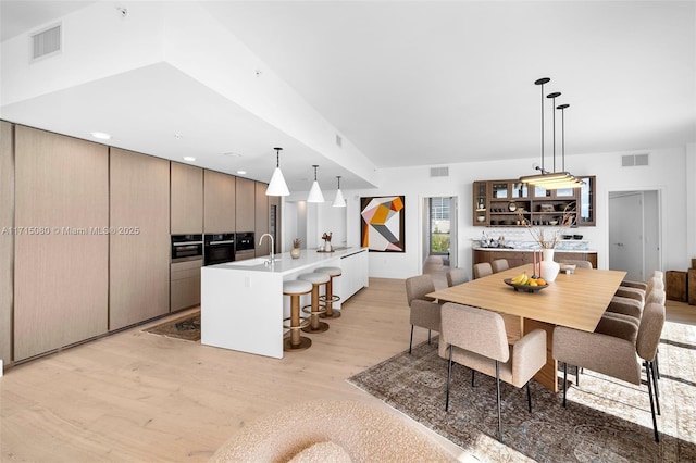 dining space featuring sink and light wood-type flooring