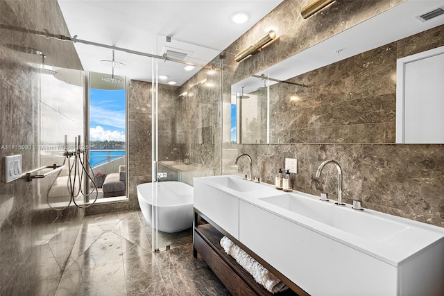 bathroom featuring plus walk in shower, vanity, a water view, and tile walls