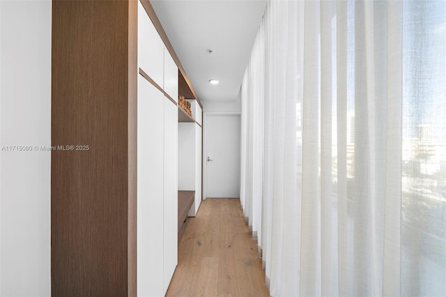 corridor with light hardwood / wood-style floors