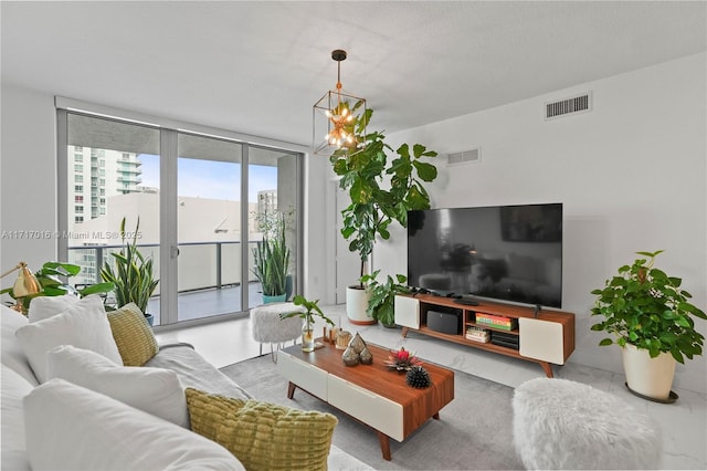 living room with an inviting chandelier and a wall of windows