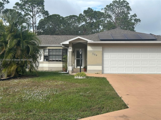 ranch-style house with solar panels, a garage, and a front lawn