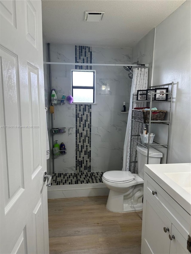 bathroom with hardwood / wood-style flooring, vanity, a shower with curtain, and a textured ceiling