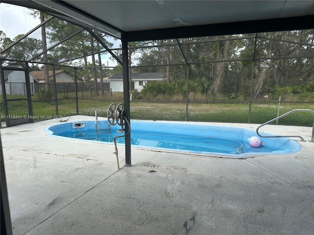 view of pool with a lawn and glass enclosure