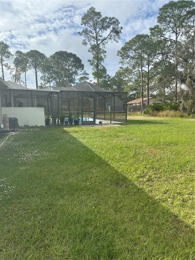 view of yard featuring glass enclosure and a swimming pool