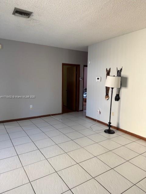 unfurnished room with a textured ceiling