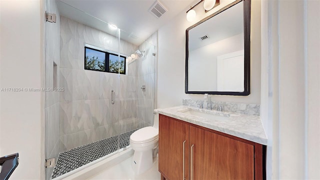 bathroom with vanity, a shower with shower door, and toilet