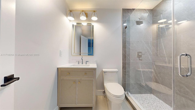 bathroom with vanity, a shower with door, and toilet