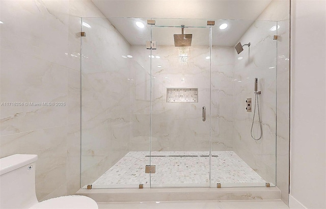 bathroom with a shower with shower door and toilet