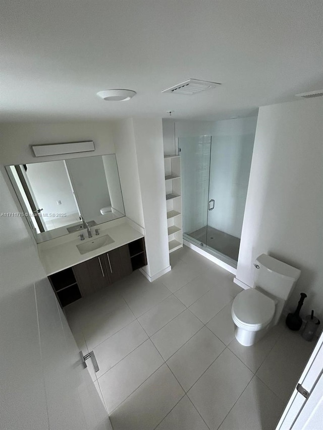 bathroom featuring toilet, tile patterned flooring, vanity, and walk in shower