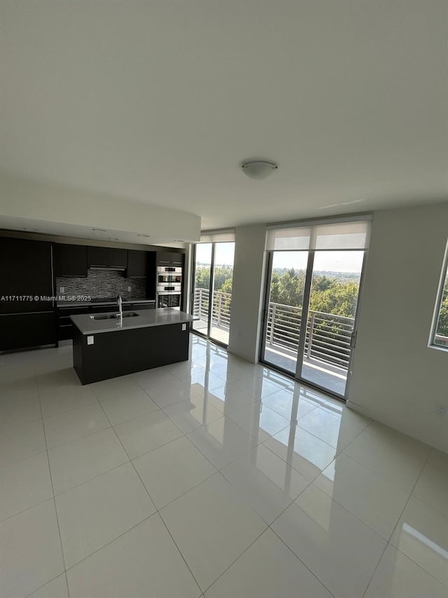 unfurnished living room featuring light tile patterned floors and sink