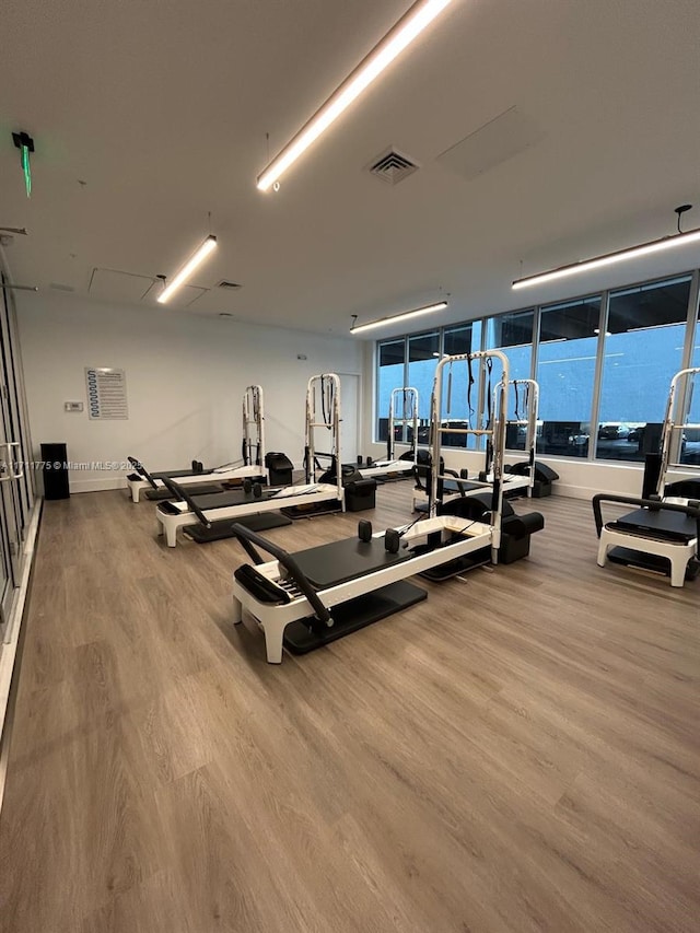 workout area with light hardwood / wood-style flooring