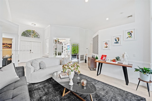 living room featuring light wood-type flooring and ornamental molding