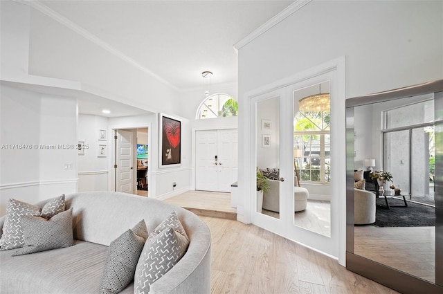 living room featuring french doors, light hardwood / wood-style flooring, and ornamental molding