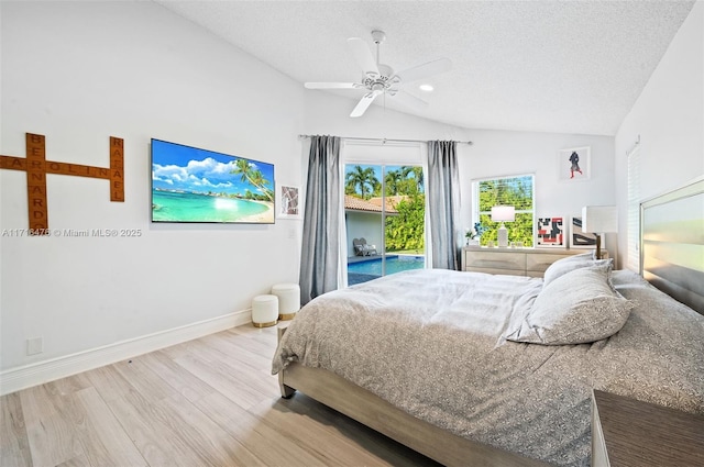 bedroom featuring a textured ceiling, access to outside, ceiling fan, hardwood / wood-style floors, and lofted ceiling