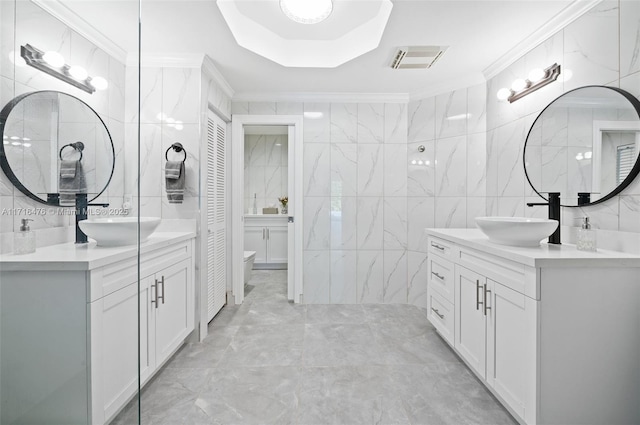 bathroom featuring vanity, toilet, tile walls, and ornamental molding