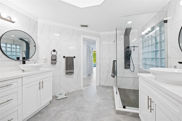 bathroom featuring a shower with door, vanity, tile walls, and ornamental molding