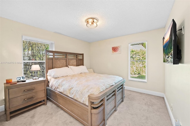 carpeted bedroom featuring a textured ceiling and multiple windows