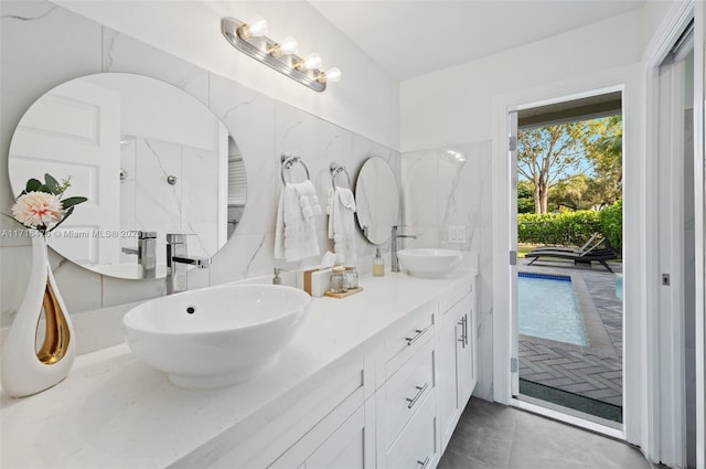 bathroom featuring a shower, vanity, and tile walls