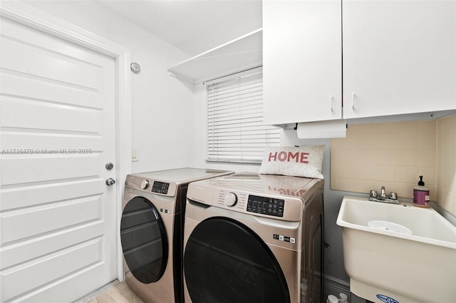 washroom featuring cabinets, separate washer and dryer, and sink