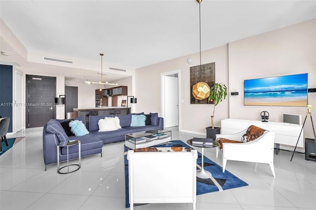 living room featuring light tile patterned floors and an inviting chandelier