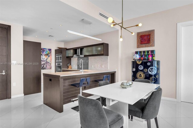 dining room with recessed lighting, baseboards, a notable chandelier, and light tile patterned flooring