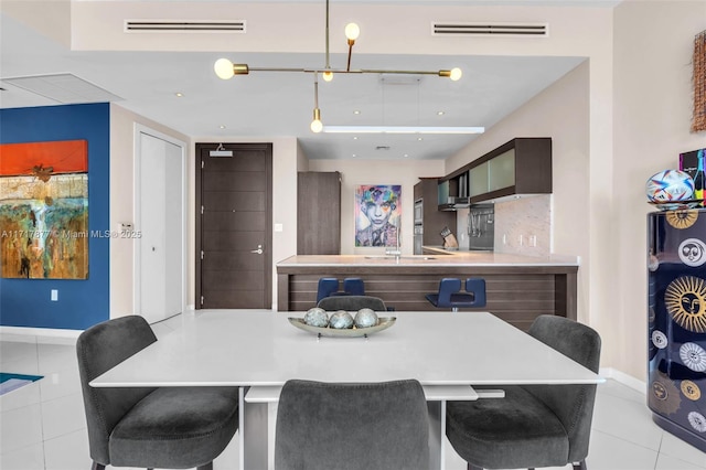 dining space featuring light tile patterned flooring, visible vents, and baseboards