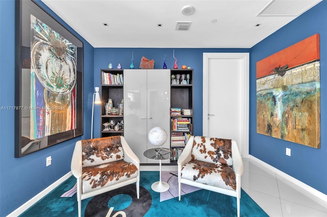 living area with visible vents, baseboards, and tile patterned flooring