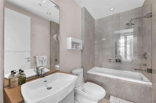 bathroom featuring toilet, a combined bath / shower with marble appearance, and a sink