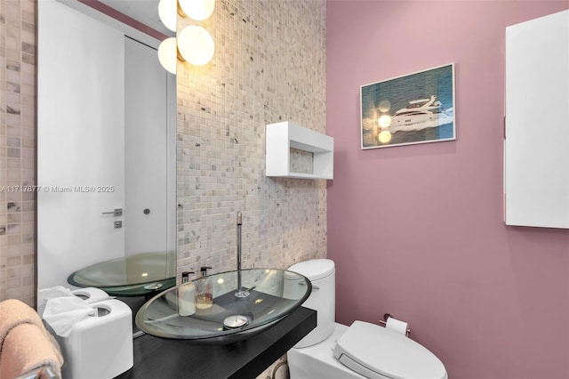 bathroom with vanity, tile walls, and toilet