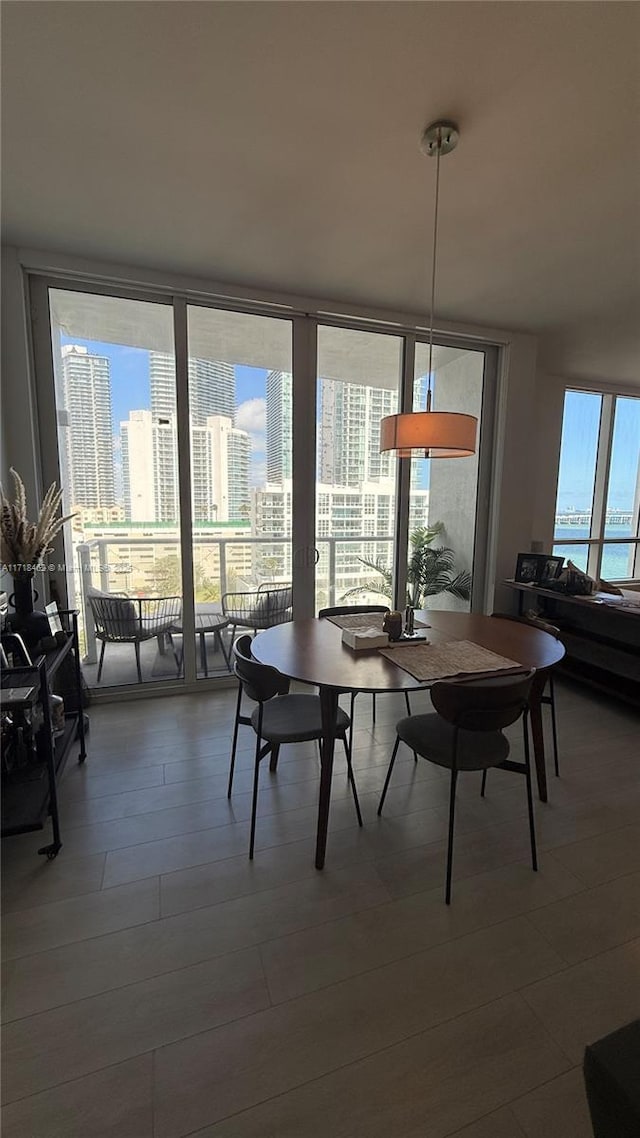 dining area with hardwood / wood-style flooring and a wall of windows