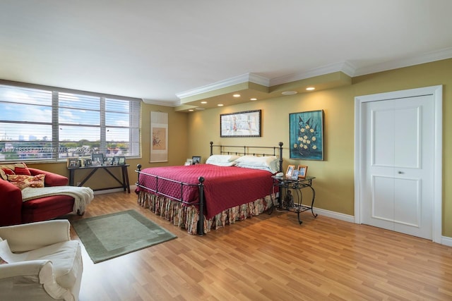 bedroom featuring a closet, ornamental molding, and light wood-type flooring