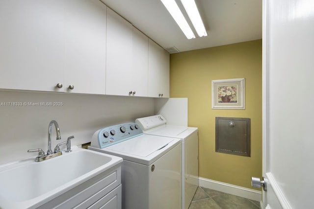 washroom featuring washer and dryer, sink, light tile patterned floors, and cabinets