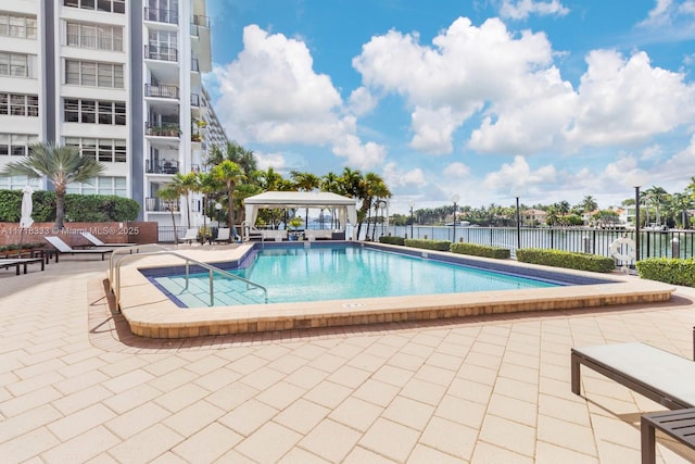 view of swimming pool with a gazebo, a patio, and a water view