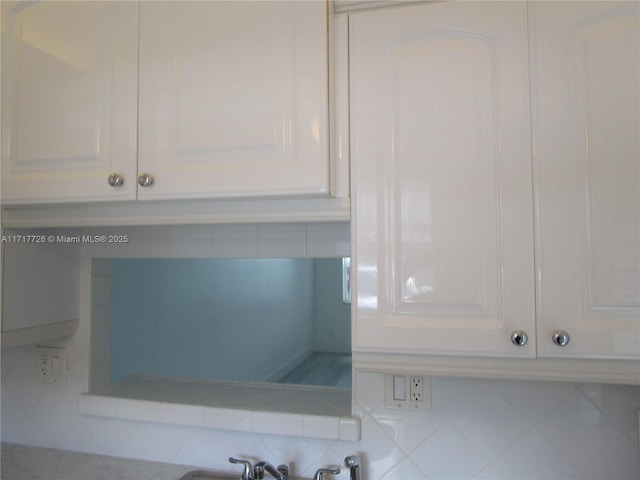 details featuring white cabinetry and tasteful backsplash