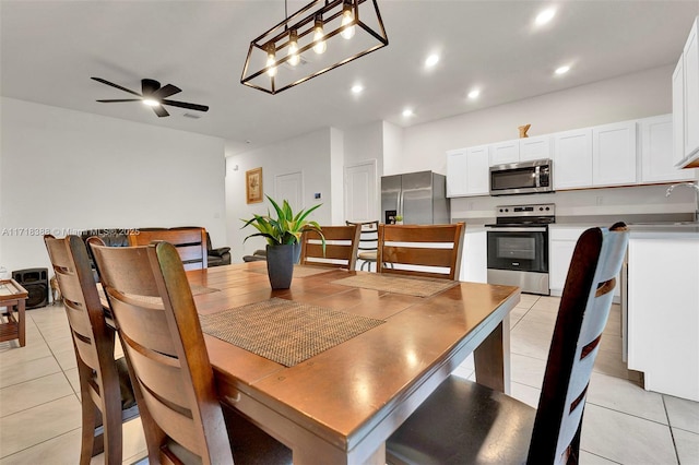 tiled dining room with ceiling fan and sink