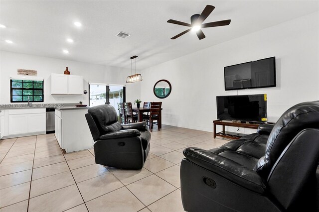 tiled living room featuring ceiling fan and sink